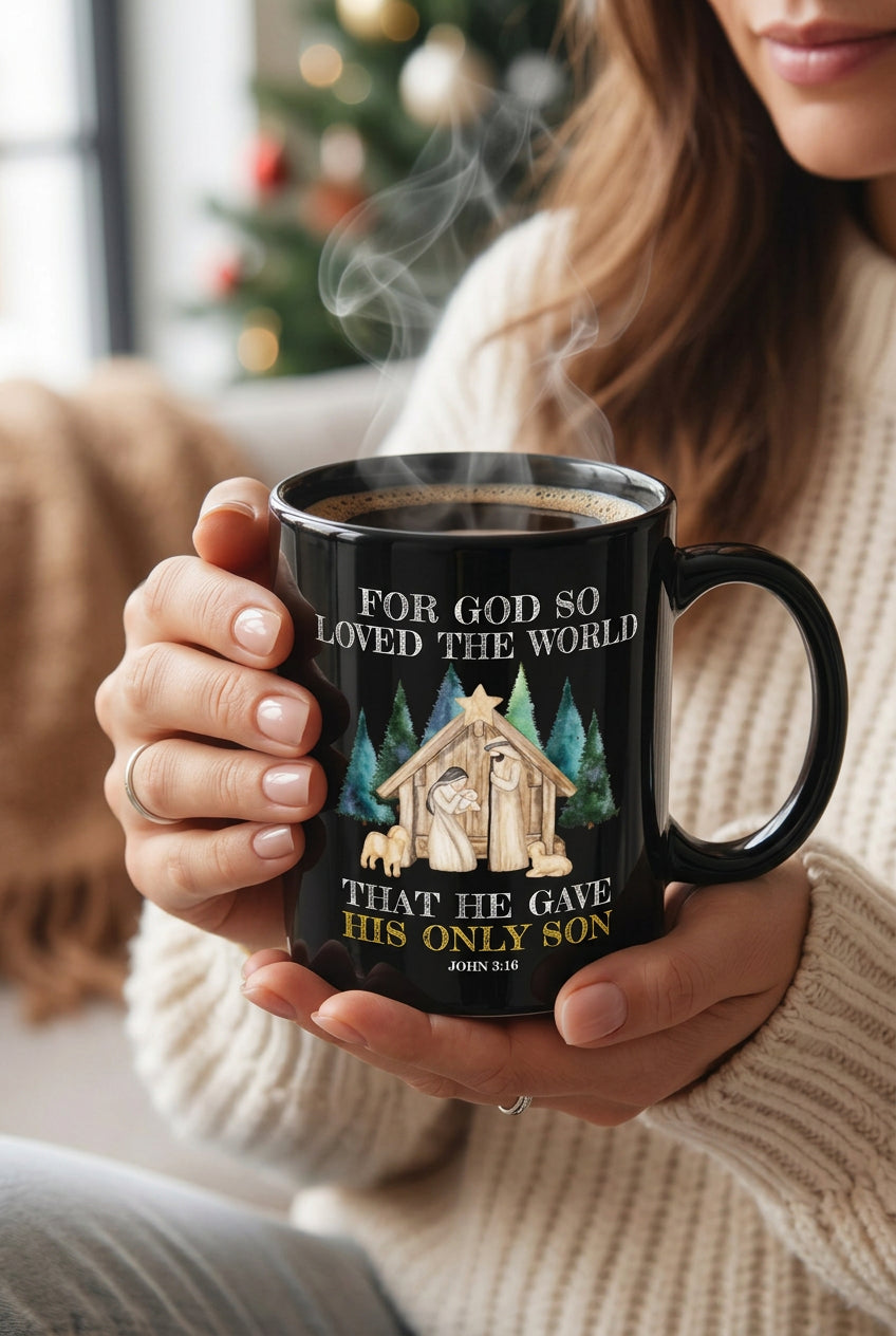 Woman holding a steaming black John 3:16 nativity mug in front of a Christmas tree, handle on the right