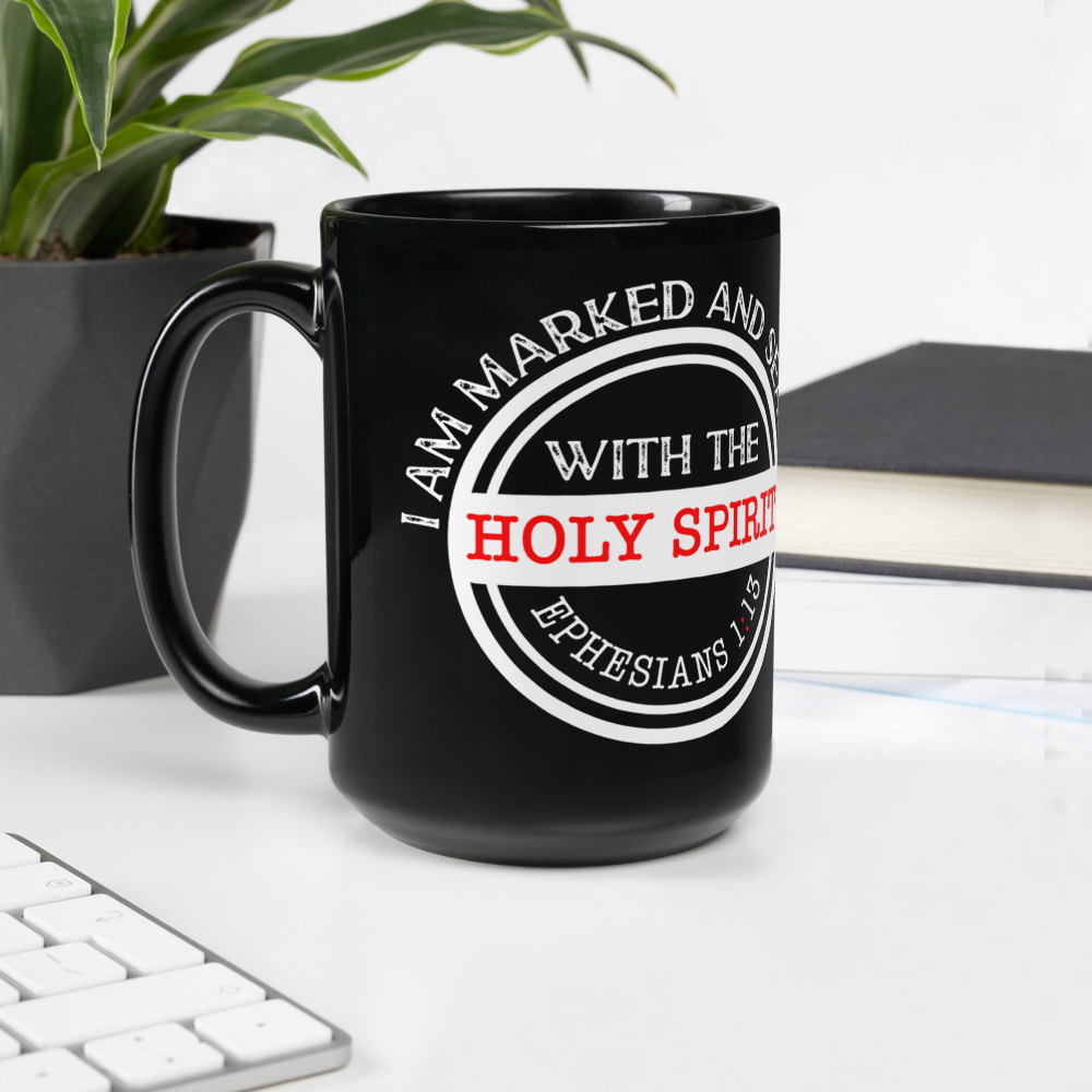 Black Ephesians 1:13 Christian mug beside a plant, keyboard and book, handle on left