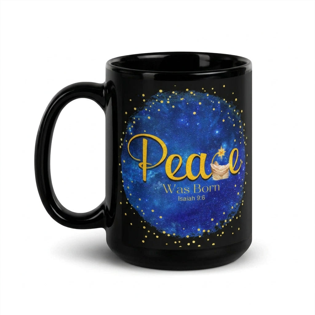 Glossy black mug with gold Peace Was Born Isaiah 9:6 lettering, a manger and star on a blue background, handle on the left
