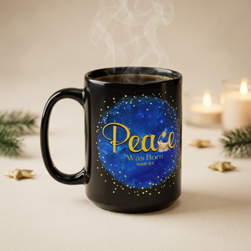 Steaming black Peace Was Born Christmas mug beside candles, evergreen sprigs and gold stars, handle on the left