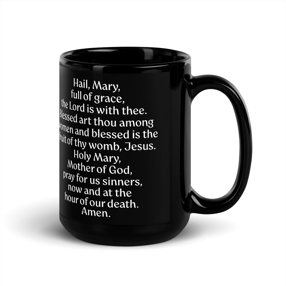 Black mug displaying the Hail Mary prayer in white lettering, handle on the right