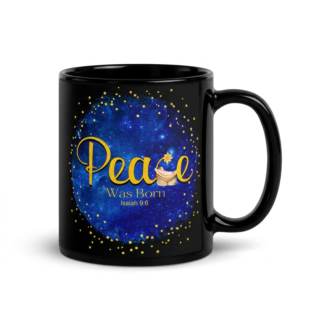 Black mug displaying gold Peace Was Born Isaiah 9:6 lettering with a manger and star against a blue background, handle on the right