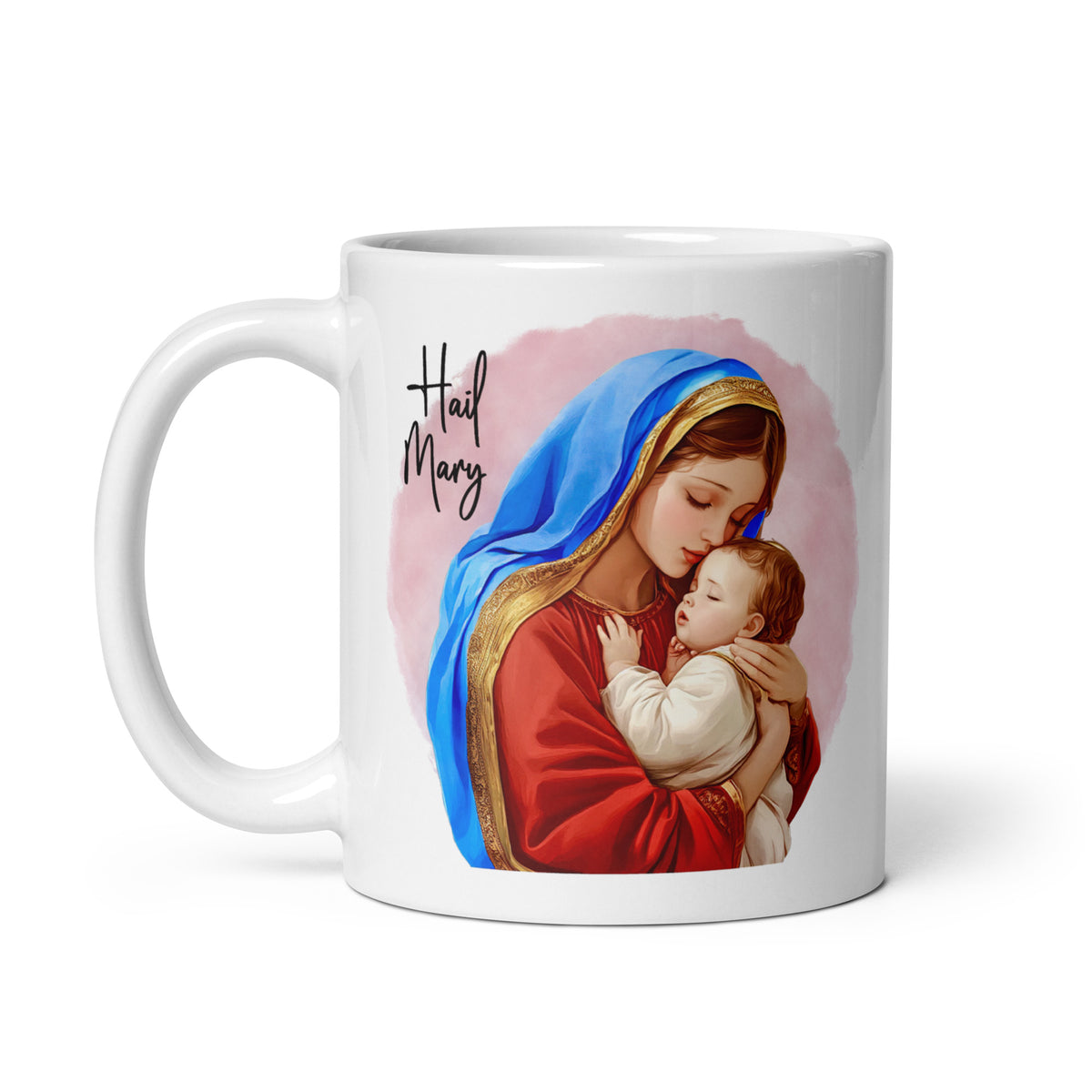 White mug with Hail Mary lettering and Mary holding Jesus against a soft pink background, handle on the left