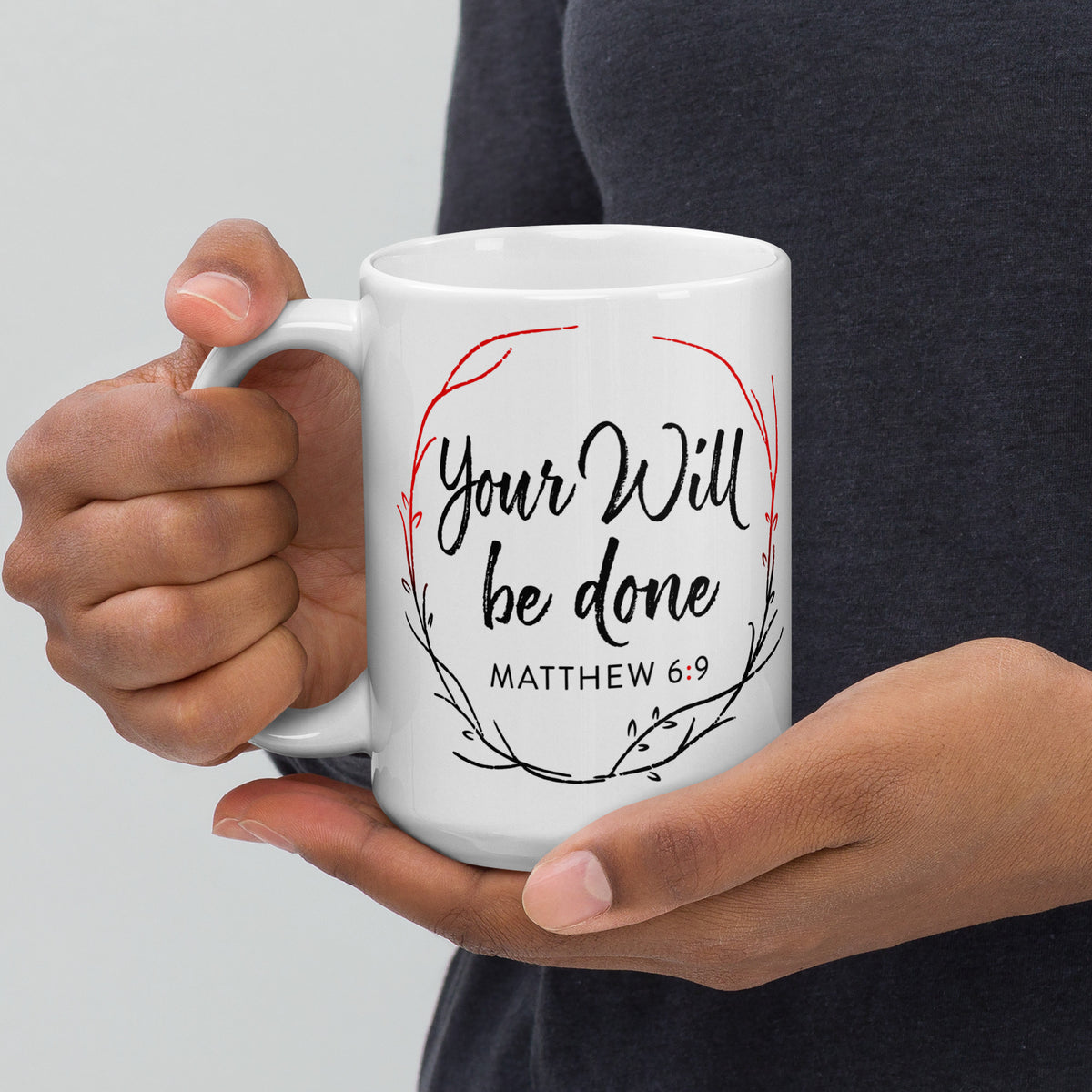 Person holding a white Your Will Be Done wreath mug in both hands