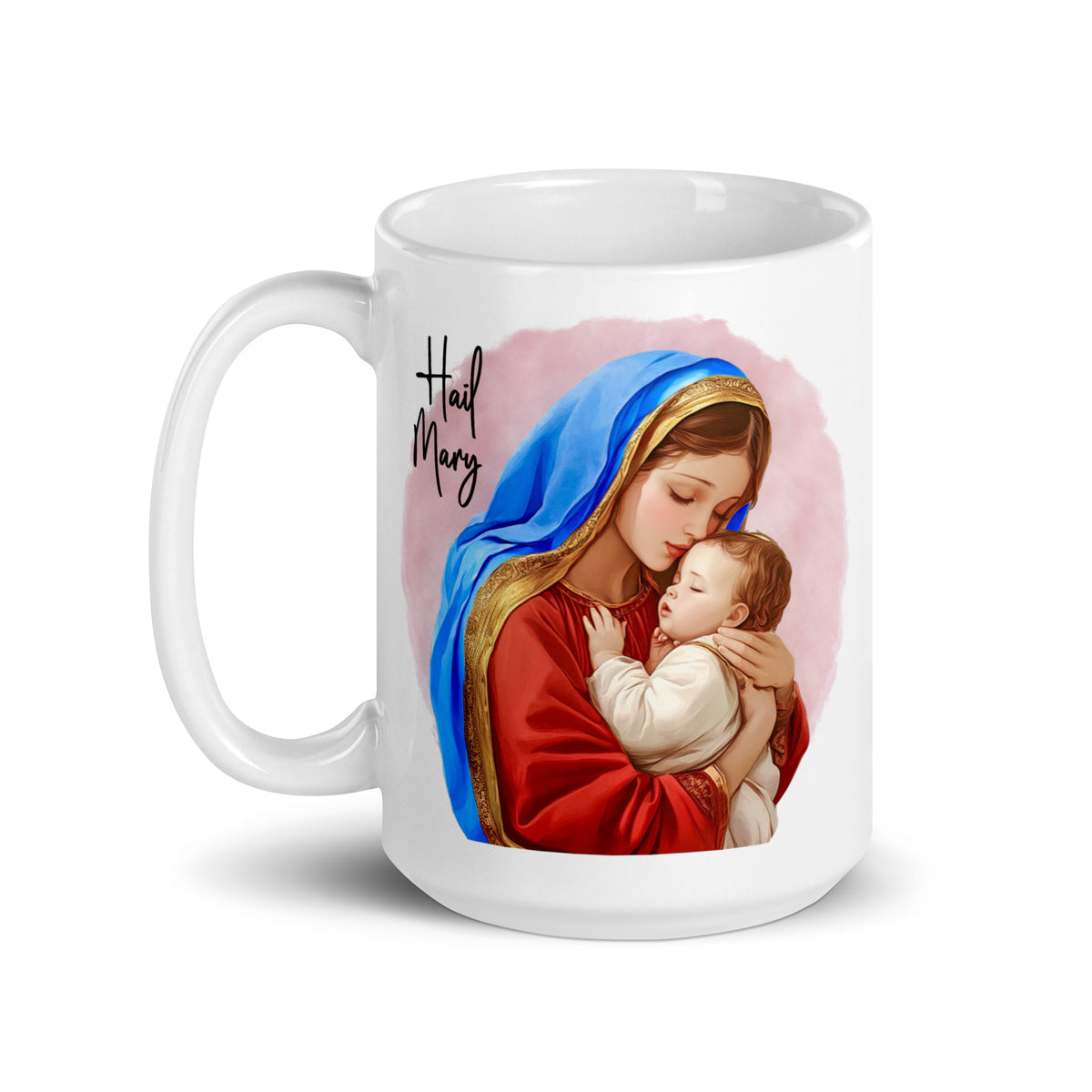 White glossy Hail Mary mug showing Mary in a blue mantle holding Jesus against a pink background, handle on the left
