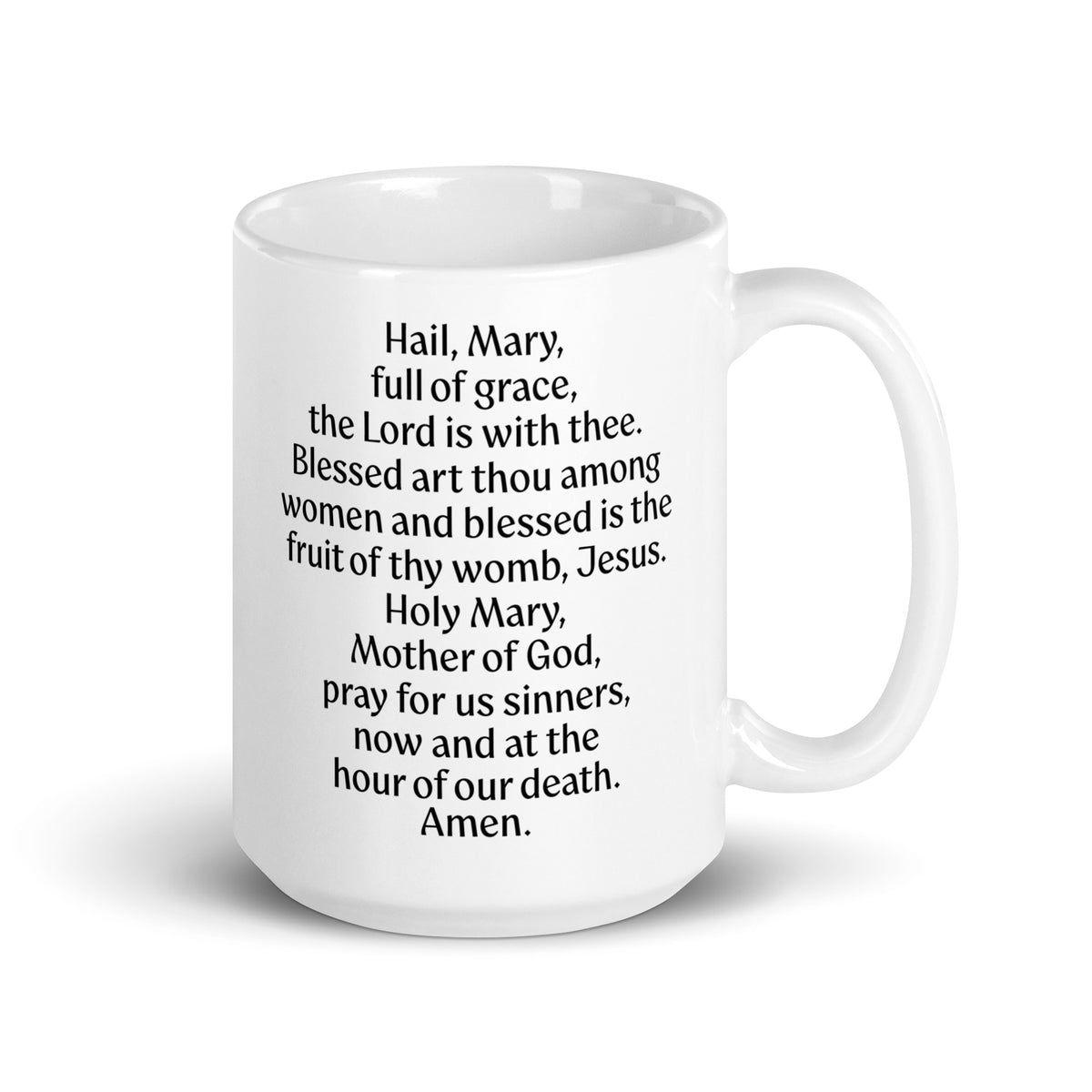 White mug displaying the Hail Mary prayer in black lettering, handle on the right